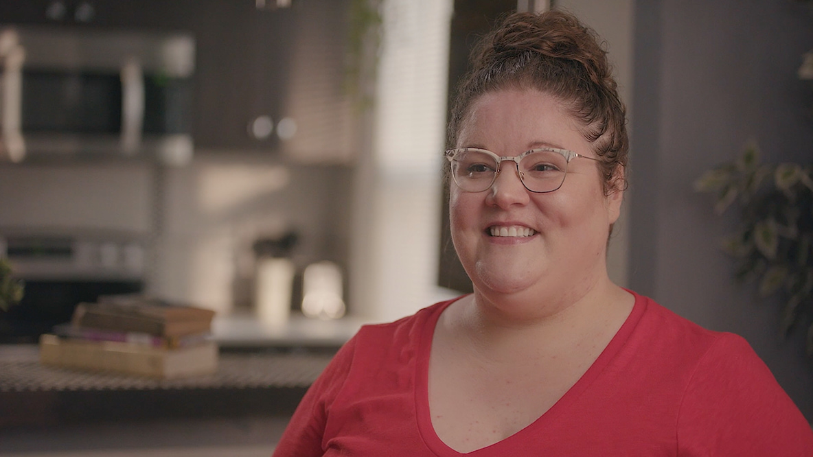 Une femme assise sur une chaise qui s’adresse à une caméra